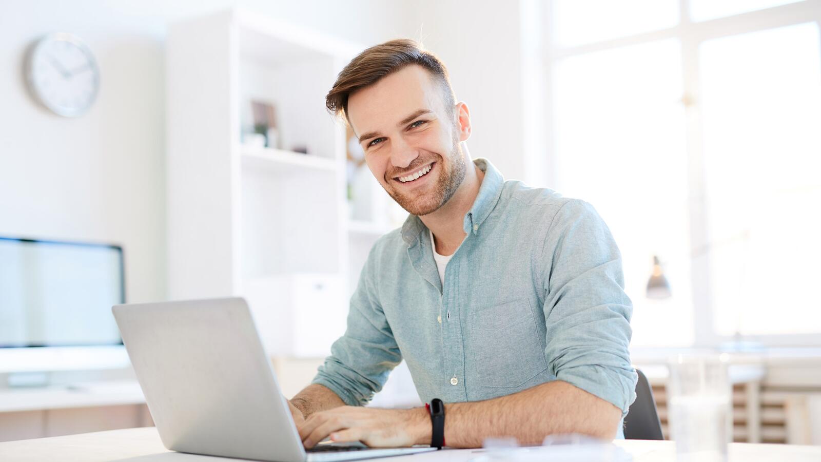 Lächelnder junger Mann am Laptop